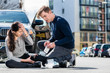 © Kzenon - Young male driver using a sterile adhesive bandage from his first aid kit to help an injured female bicyclist on the street
