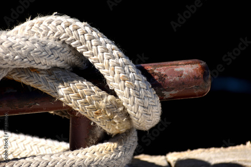 Rope knotted at a pier. With bollard.