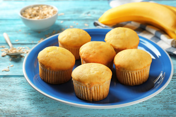 Poster - Plate with fresh banana muffins on table