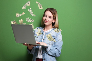 Smiling blond girl with laptop on green background