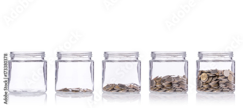 Photographie Thai coin (baht) in clear glass jar with different level from less to more
