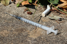Used And Discarded Syringe On The Street