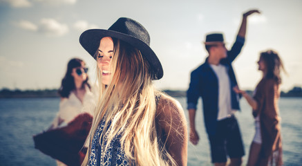 Group of friends dancing and celebrating on beach, boho party