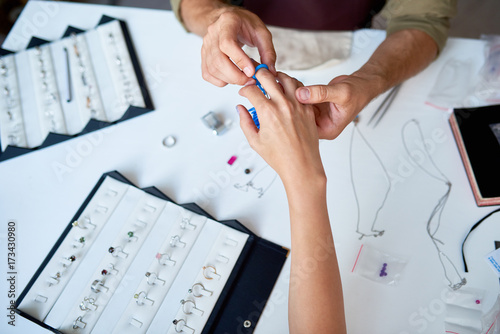 Fotografie, Obraz Closeup of man checking ring size of elegant female hand in jewelry shop