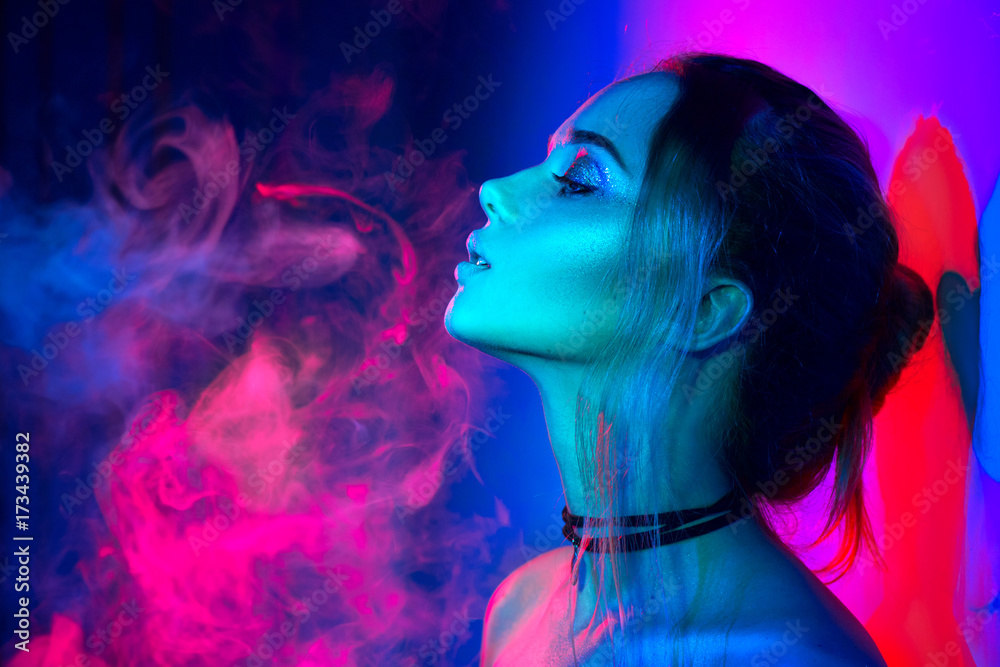 Beautiful sexy girl with trendy make-up in colorful bright lights - obrazy, fototapety, plakaty 