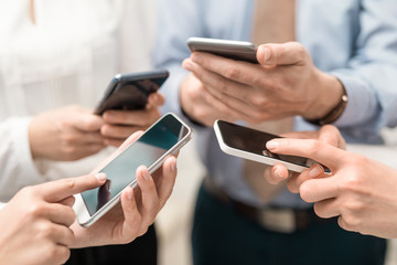 Friends having fun together with smartphones.