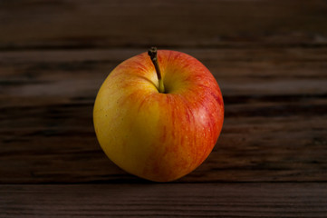 Ripe red apple on rustic dark wooden table