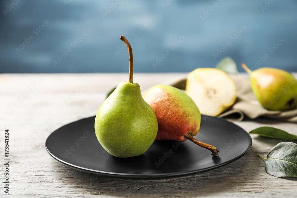 Ripe pears on black plate