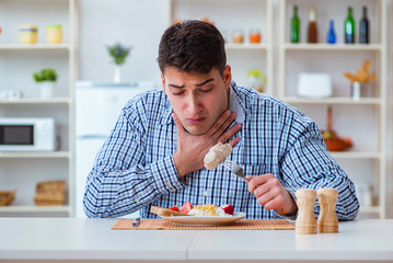 Wall Mural - Man eating tasteless food at home for lunch