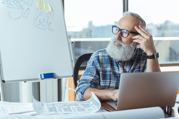 Wall Mural - Old gray-haired male is taking pause at job