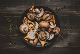 Fototapeta  - Fresh mixed forest mushrooms on the wooden black table