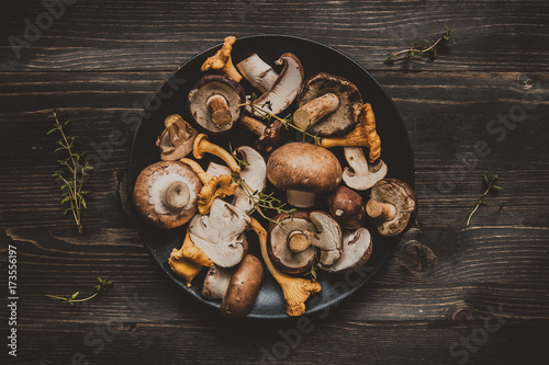 Fotomural Fresh mixed forest mushrooms on the wooden black table