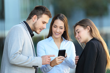 Wall Mural - Group of executives using a phone on the street