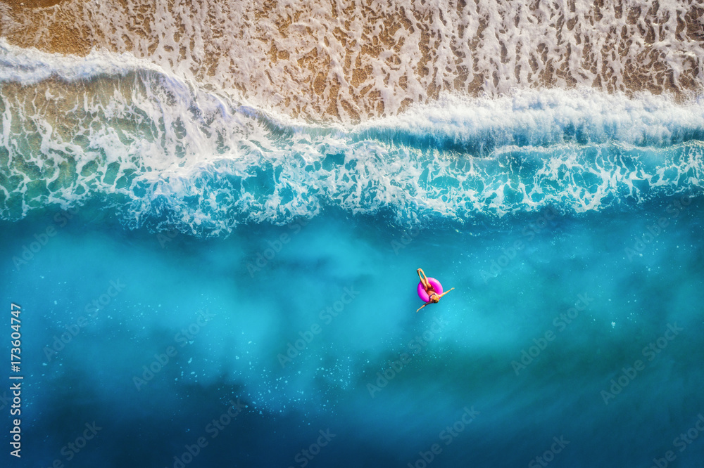 Aerial view of slim woman swimming on the pink swim ring in the ...