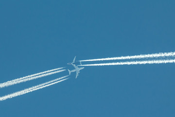 Two passengers jets at the same time in high blue sky