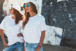 © Alena Ozerova - Models wearing plain tshirt and sunglasses posing over street wall