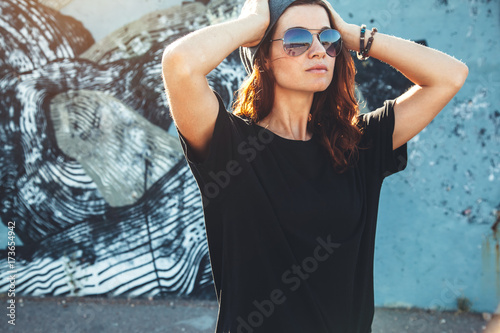 Fotomural Model wearing plain tshirt and sunglasses posing over street wall