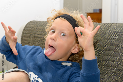 Little Boy With Blond And Curly Hair Making Faces Buy This Stock
