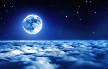 Wall Mural - bright full moon in a starry night sky above dreamy clouds with soft glowing light