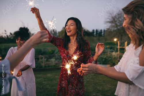 Fotografía Multi-ethnic friends enjoying party with sparklers