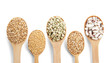 Wooden spoons with different grains on white background
