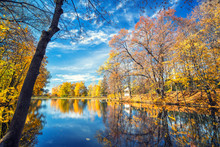 Sunny Autumn Landscape With Blue Sky Over The Lake