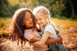 © svetabezu - Two happy girls as friends hug each other in cheerful way. Little girlfriends in park.