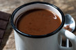mug of hot sweet chocolate on a wooden table, closeup