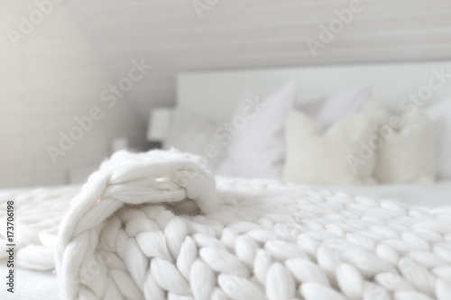Fotografía White nordic bedroom interior with knit plaid