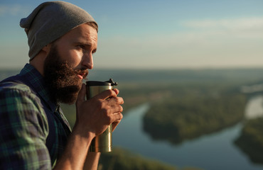 Hipster having drink in nature