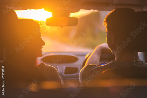 Cuadros en Lienzo The couple drive a car on the background of the sunset