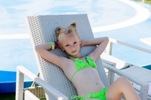 Young Girl In A Swimsuit On A Shelf By The Pool
