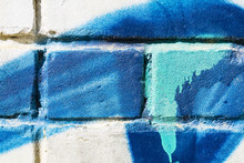 Old White Brick Wall With Blue Turquoise Graffiti For Background. The Texture Of The Cracked Two-ton Brick.