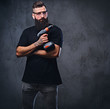 © Fxquadro - A man holds a drill over grey background.