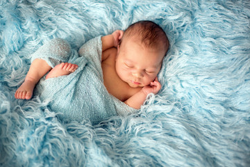 Canvas Print - Happy smiling newborn baby in wrap, sleeping happily in cozy fur