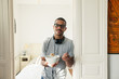© BONNINSTUDIO/Stocksy - Latin man in bedroom holding a cereal bowl.