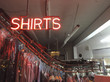 © Paul Edmondson/Stocksy - Neon SHIRTS sign in window of dry cleaner business