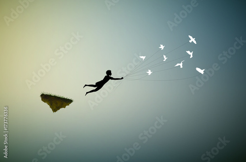 Photographie boy is flying away and holding pigeons, fly in the dream land,fly away, shadows,