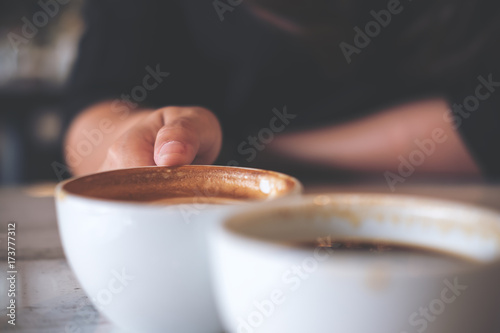Fotografie, Obraz Close up image of two people clink white coffee mugs on wooden table in cafe