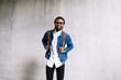 © BONNINSTUDIO/Stocksy - African american man standing in front of a wall.