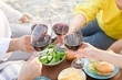 © Savchenko - Hands Friends toasting red wine glass and having fun outdoors.