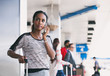 © Sean Locke Photography/Stocksy - Airport: Attractive Female Passenger Calling For Ride Pickup