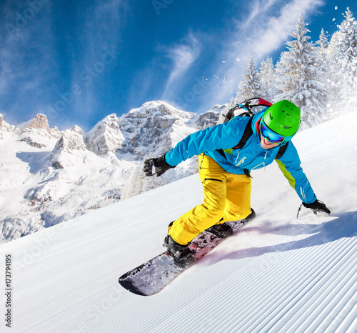 Snowboarder going downhill in high mountains