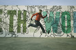 © CACTUS Blai Baules/Stocksy - Man jumping in front of a graffiti wall