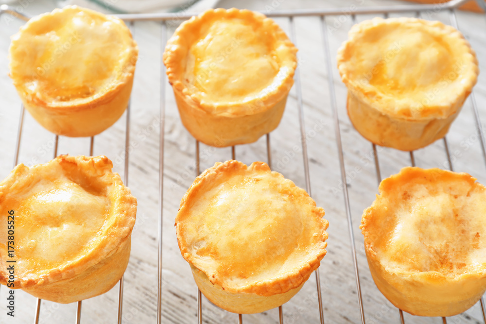 Delicious meat mini pies on baking grid, closeup
