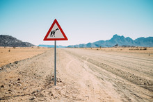 Empty Desert Road With A Yield For Giraffes Sign Post