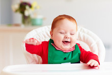 Cute Happy Infant Baby Boy In Elf Costume Sitting In Highchair