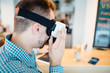 © Dusko - Young handsome man sitting in cyber cafe and using virtual reality headset or glasses.