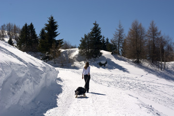 The woman goes up pulling the sled