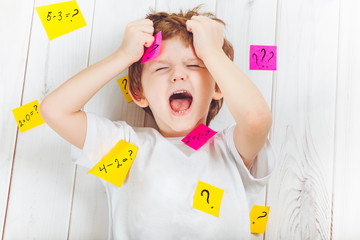 Crying child with question symbol with stickers on his head and around.
